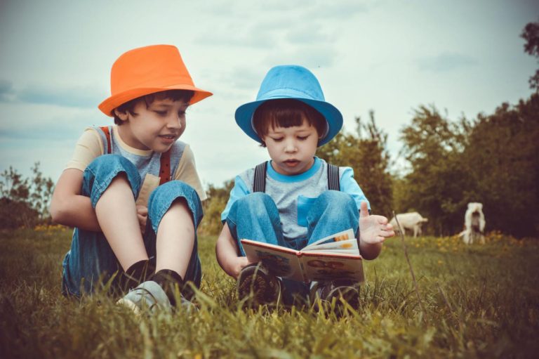 Two boys reading a book