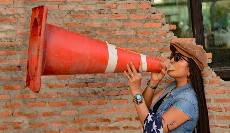 woman highway cone bullhorn flag America