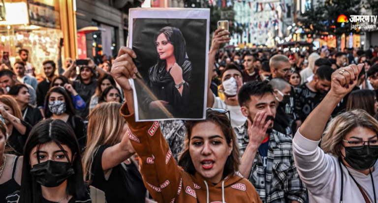 protesters waves picture of Mahsa Amini during protests in Iran sept 2022 - Youtueb screen grab
