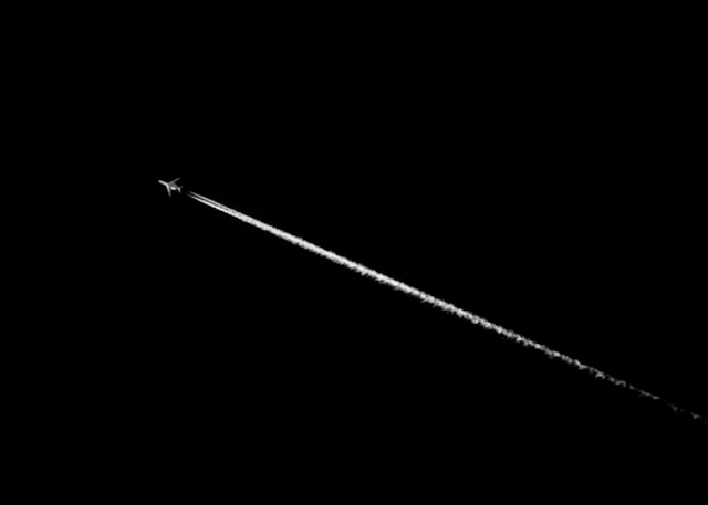 Passanger jet contrail in a dark sky