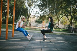 women on a swing set talking