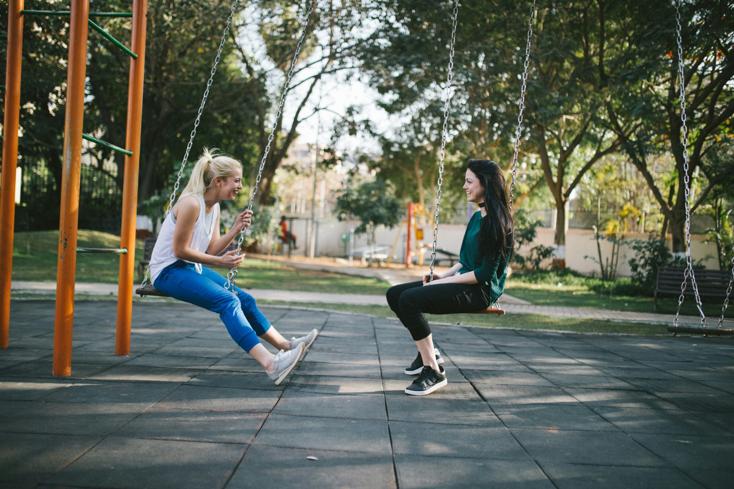 women on a swing set talking