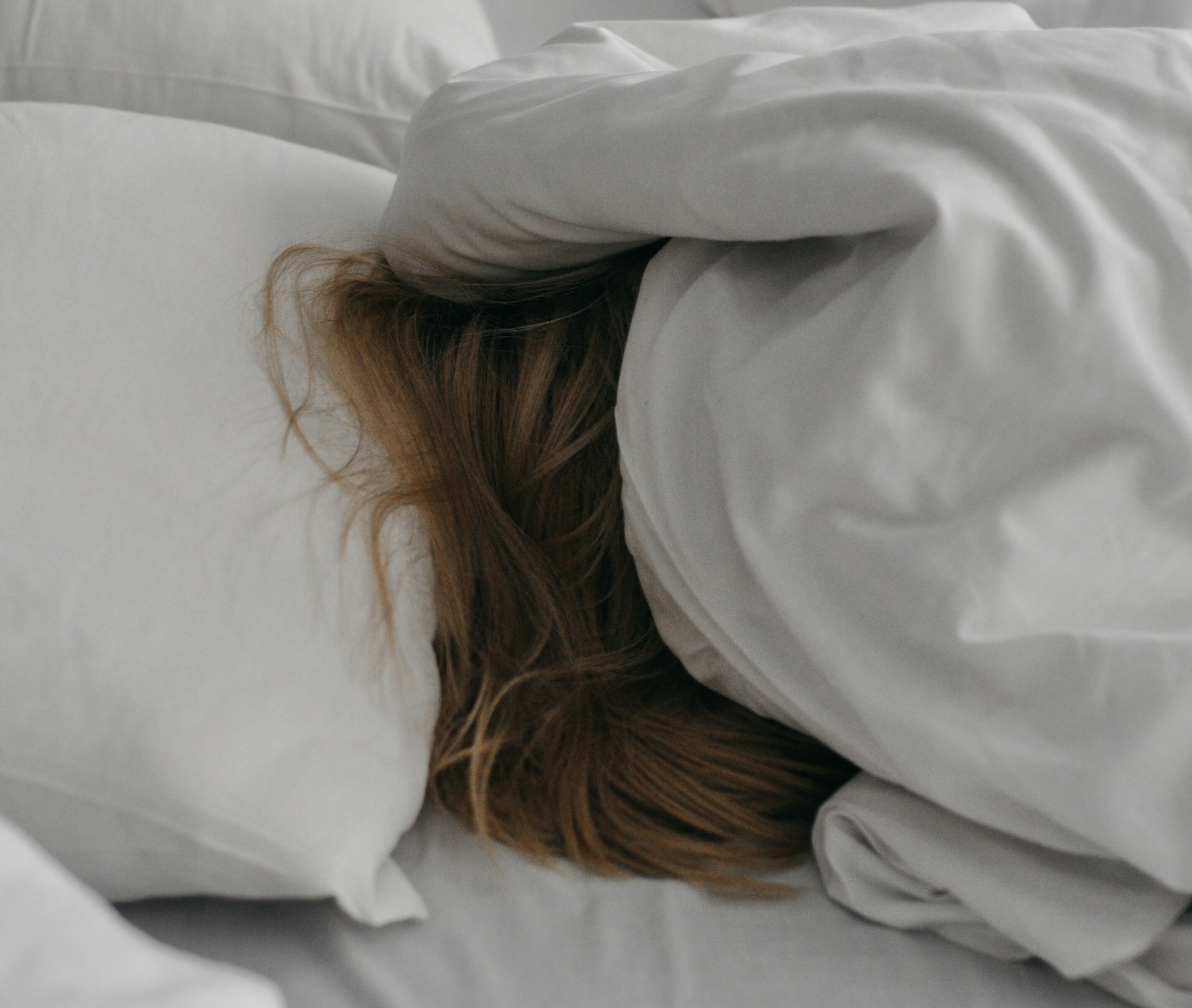 woman sleeping with blanket over her head