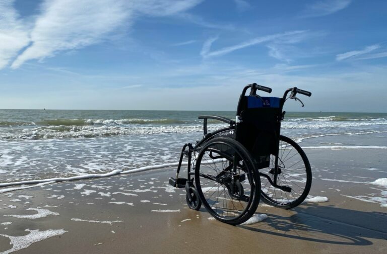 wheelchair on the beach as tide rolls in