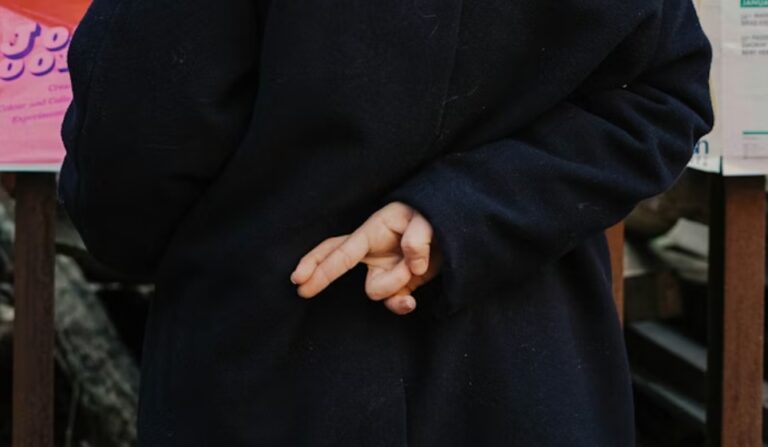woman with her fingers crossed behind their back