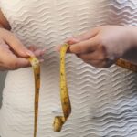 woman measiring her wasitline