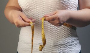 woman measiring her wasitline