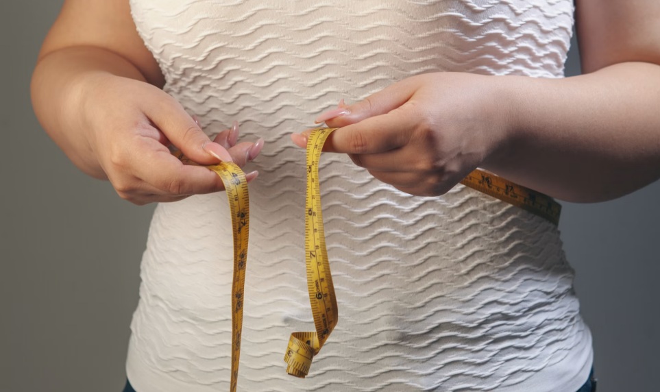 woman measiring her wasitline