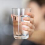 a woman holding a glass of water
