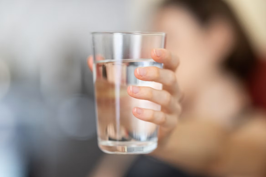 a woman holding a glass of water