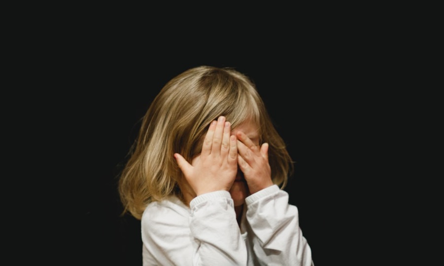 little girl with eyes covered - Photo by Caleb Woods on Unsplash