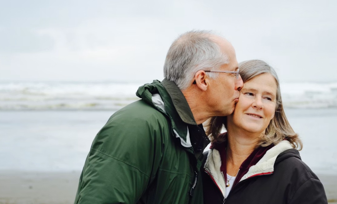 senior couple kiss on the beach