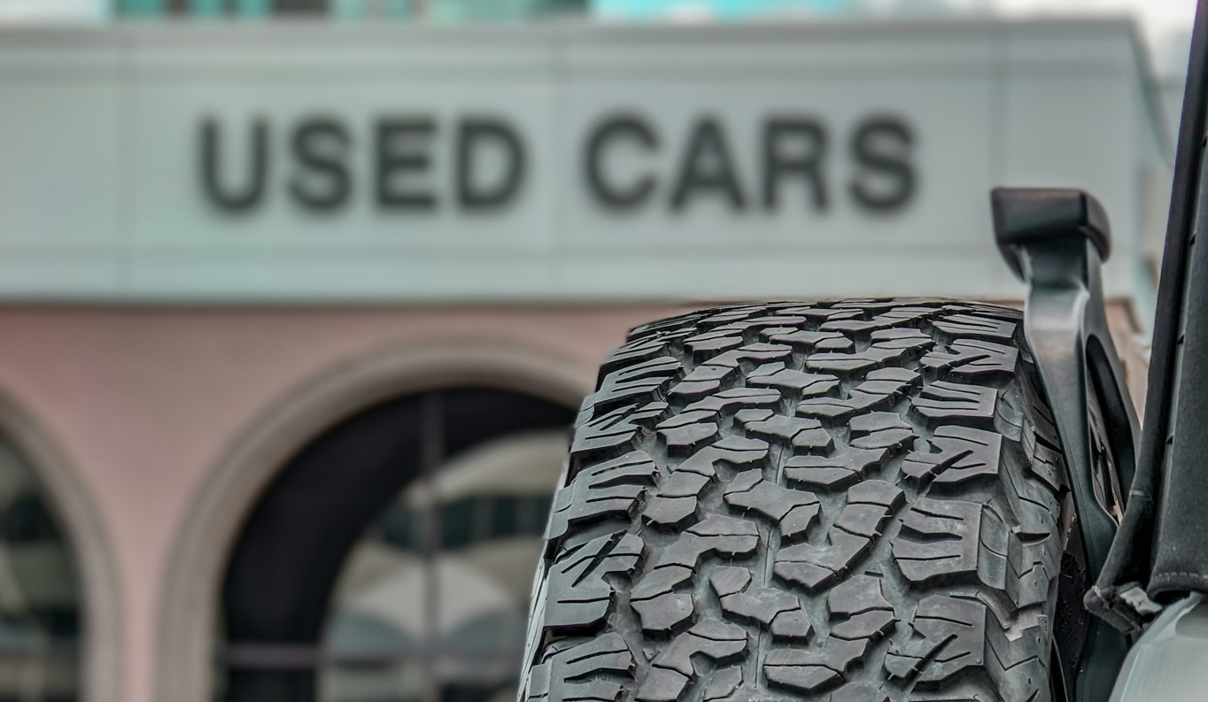 Used cars sign tire in the foreground - Koons Automotive Unsplash