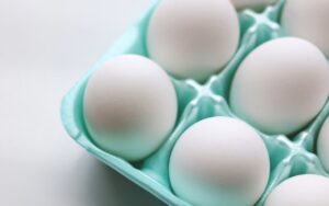 White eggs in light green foam carton