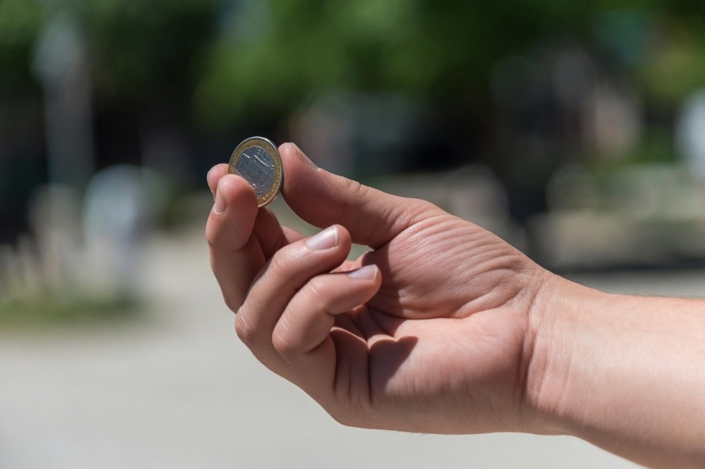 hand with a coin in it about to be flipped