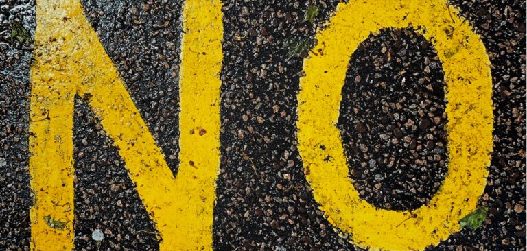 the word no in yellow paint on asphalt